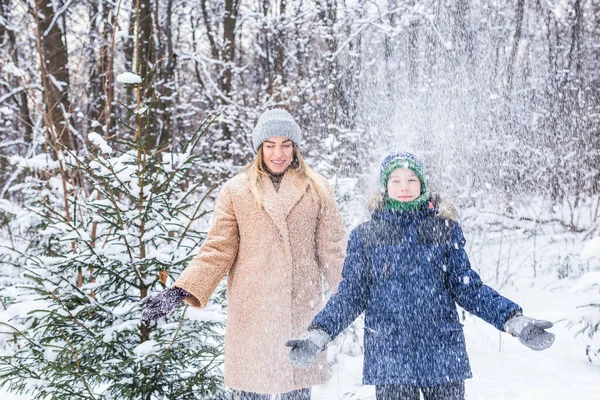 Parenting, fun et concept de saison - Bonne mère et son fils s'amusent et jouent avec la neige dans la forêt d'hiver — Photo