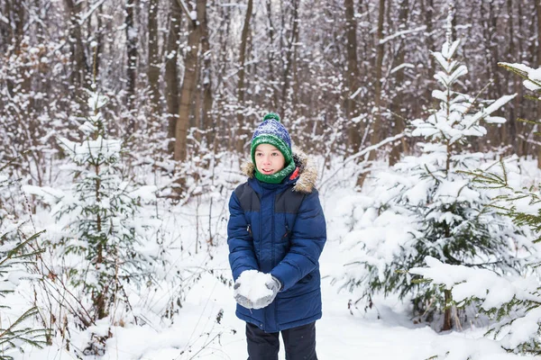 Rapaz feliz a atirar neve. Conceito de criança, estação e inverno. — Fotografia de Stock