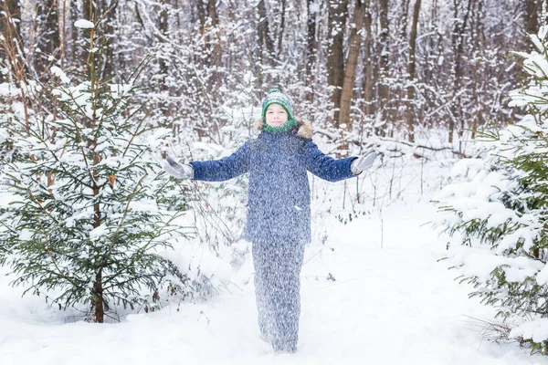 Lindo joven juega con la nieve, divertirse, sonrisas. Adolescente en el parque de invierno. Estilo de vida activo, actividad invernal, juegos al aire libre de invierno, bolas de nieve. — Foto de Stock