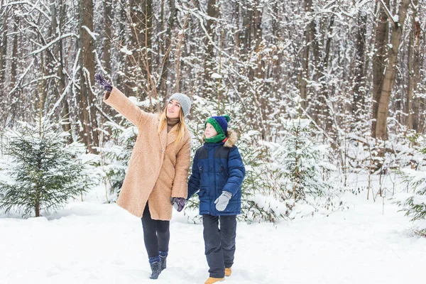 Portret szczęśliwej matki z synem w zimie na świeżym powietrzu. Śnieżny park. Samotny rodzic. — Zdjęcie stockowe