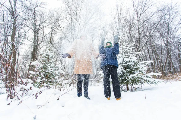 Parenting, fun et concept de saison - Bonne mère et son fils s'amusent et jouent avec la neige dans la forêt d'hiver — Photo