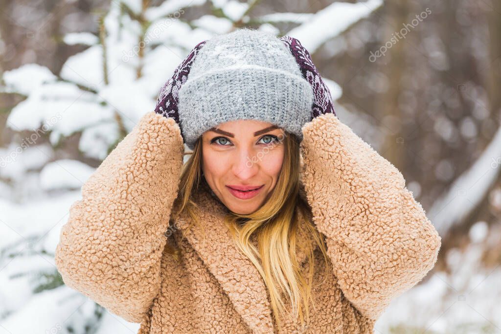 Attractive young woman in winter time outdoor. Snow, holidays and season concept.