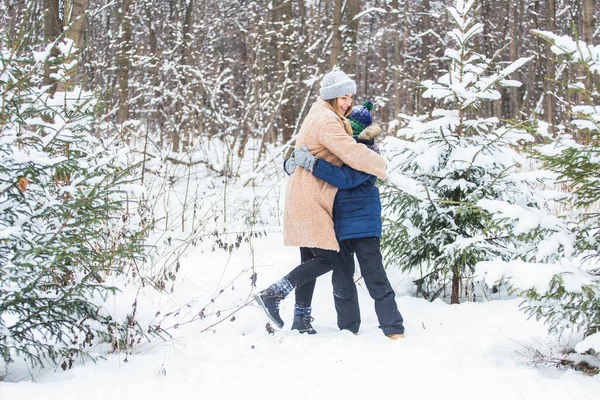 Conceito de diversão e temporada - Mãe e filho felizes se divertindo e brincando com a neve na floresta de inverno — Fotografia de Stock