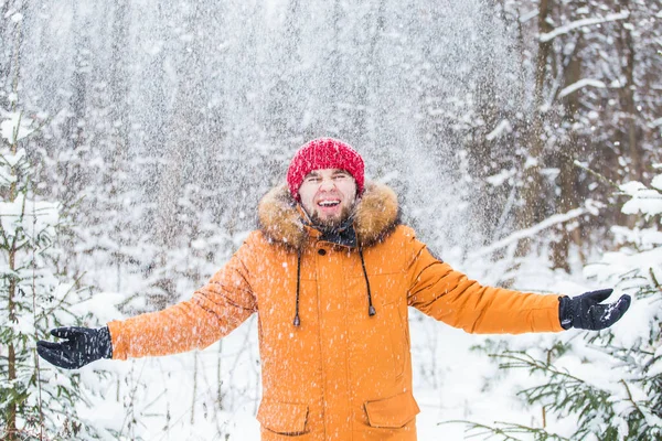 Jovem jogando neve na floresta de inverno. Um tipo a divertir-se ao ar livre. Actividades de Inverno. — Fotografia de Stock