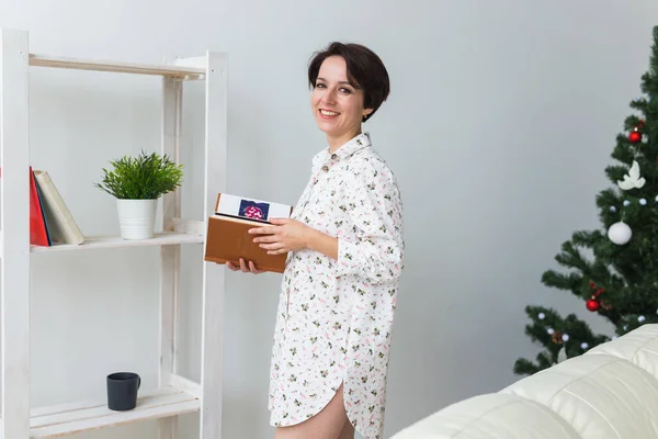 Noël, vacances et concept de personnes - heureux livre de lecture jeune femme à la maison. — Photo