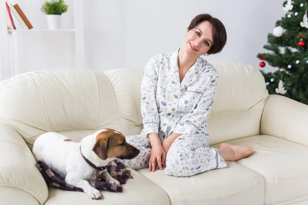 Happy young woman with lovely dog in living room. Holidays concept. — Stockfoto