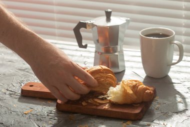 El desenli sanat masasında Türk kahvesinin yanında duran kruvasanı alır. Öğle yemeği konsepti mi yoksa sabah mı başlıyor?