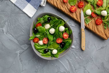 Mozarella peynirli, domatesli ve ıspanaklı taze salata. Sağlıklı beslenme yemekleri, üst manzara..