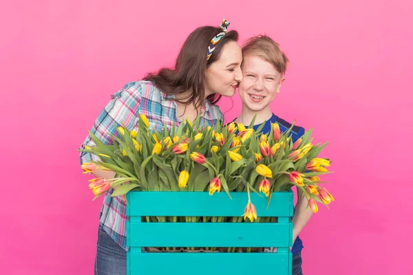 Family portrait sister and teenager brother with tulips on pink background — Stock Photo, Image