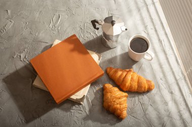 Sabah kahvesi, Türk fincanı ve masada iki kitap olan kruvasanlar için sakin bir hayat. Öğle yemeği konsepti mi yoksa sabah mı başlıyor?