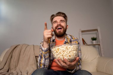 Kanepede televizyon izleyen bekar bir adam.