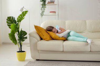 Kırık bileği ya da kanepede yatan kolu olan bir çocuk. İyileşme ve hastalık konsepti.