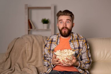 Kanepede televizyon izleyen bekar bir adam.