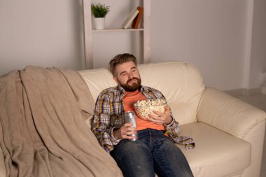 Kanepede televizyon izleyen bekar bir adam.