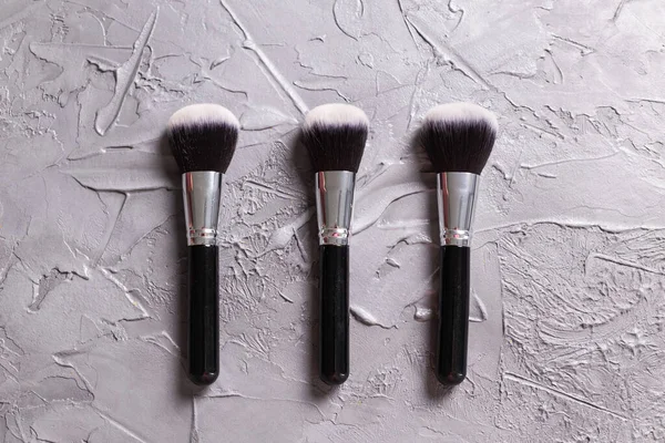 Ovanifrån av make-up borstar på grå bakgrund — Stockfoto