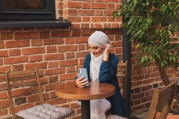 Mulher muçulmana feliz ter chamada de vídeo no smartphone na cidade — Fotografia de Stock