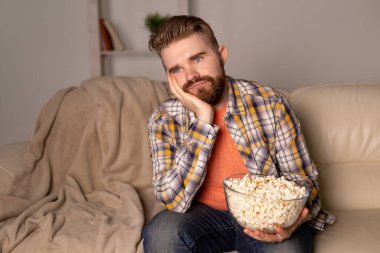 Kanepede televizyon izleyen bekar bir adam.