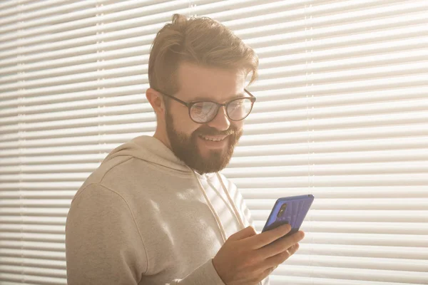 Hombre feliz usando teléfono móvil en casa o en la oficina — Foto de Stock