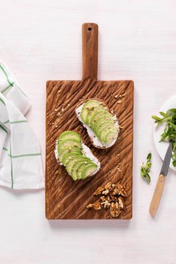 Avokado sandviçi. Yukarıdan taze kesilmiş avokadolarla yapılmış koyu çavdar ekmeği. Kahvaltı konsepti.