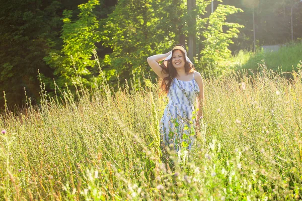 Žena kráčí na poli v létě slunečný den. — Stock fotografie