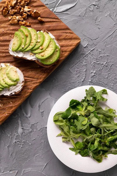 Avocat tranché sur pain grillé aux noix et roquette — Photo