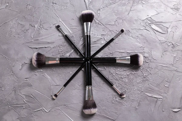 Ovanifrån av make-up borstar på grå bakgrund — Stockfoto