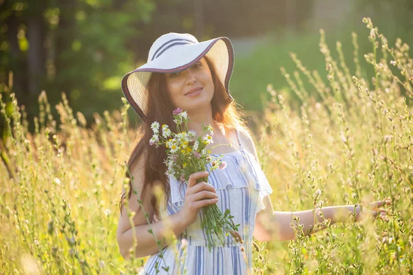 Junge Frau pflückt an Sommerabenden Blumen auf der Wiese — Stockfoto