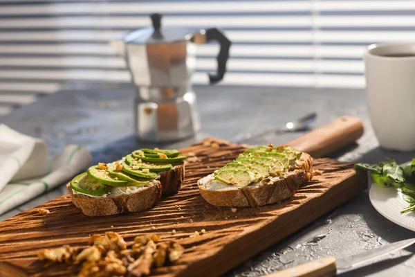 Нарезанный авокадо на хлебе с орехами и кофе. Концепция завтрака и здорового питания. — стоковое фото