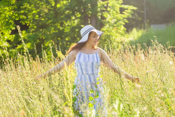 Frau läuft an einem sonnigen Sommertag auf einem Feld. — Stockfoto