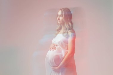 Zarif hamile kadın açık renk kumaş giyiyor. Hamilelik, fantezi ve masal kavramı.