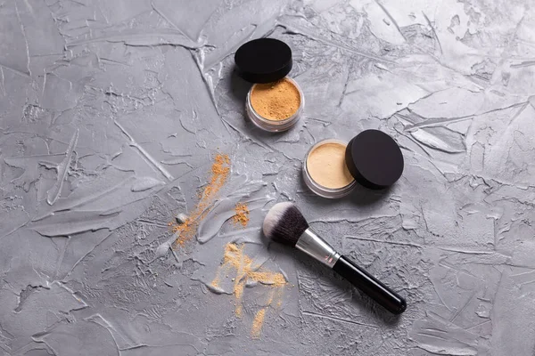 Mineral powder of different colors with a brushes for make-up on wooden background.