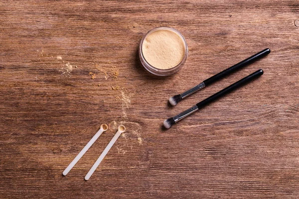 Mineral powder foundation with brushes on a wooden background. Eco-friendly and organic beauty products
