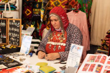 UFA, RUSSIA - 10 Temmuz 2021: Bashkir kadını Ufa 'da Folkloriada sırasında ulusal giysiler ördü
