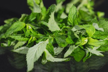 Siyah arka planda nane yaprakları. Masada duran nane şekeri.