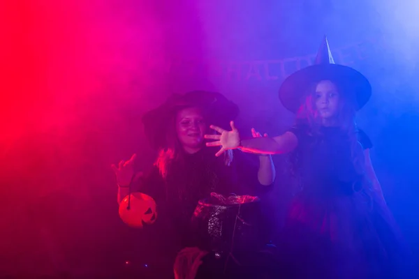 Enfant drôle fille et femme en costumes de sorcières pour Halloween avec citrouille Jack. — Photo