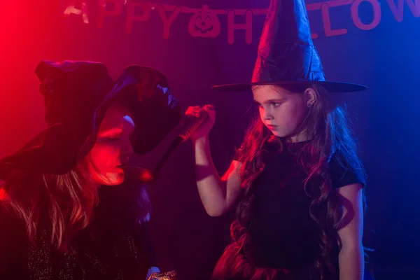 Смешная девочка и женщина в костюмах ведьм на Хэллоуин. — стоковое фото