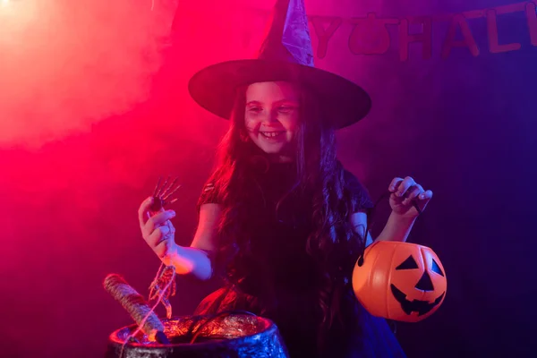 Enfant drôle fille en costume de sorcière pour Halloween avec citrouille Jack. — Photo