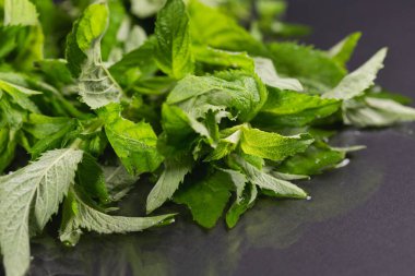 Siyah arka planda nane yaprakları. Masada duran nane şekeri.