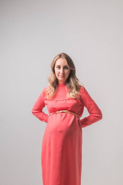 Beyaz duvarda hamile bir kadın var.,