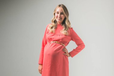 Beyaz duvar arka planında hamile kadın, metin için boşluk