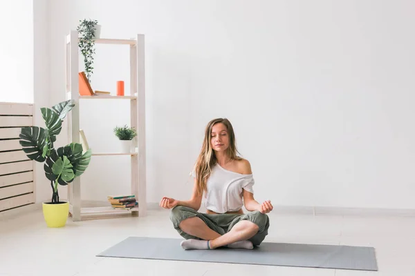 Mujer joven en posición de loto mientras medita. Práctica de mindfulness, bienestar y autoconcepto. — Foto de Stock