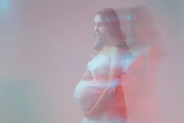 Элегантная беременная женщина, стоящая в светлой ткани. Беременность, фантазия и концепция сказки. — стоковое фото