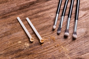 Yüz için mineral tozu ve tahta arka planda toz ve çehre için fırça. Çevre dostu ve organik kozmetikler.