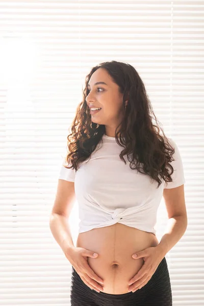 Uma mulher grávida a tocar na barriga. Gravidez e licença de maternidade — Fotografia de Stock