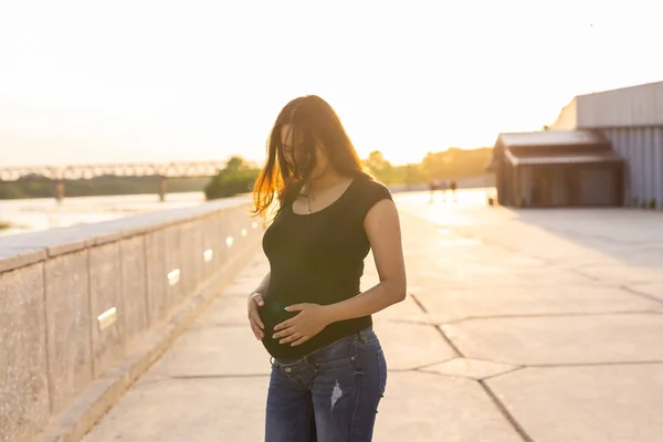 Donna ispanica incinta nel parco, pancia commovente — Foto Stock