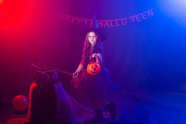 Funny niña en traje de bruja para Halloween con Jack de calabaza. — Foto de Stock