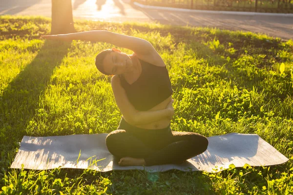 Gravid kvinna som gör yoga i naturen utomhus. Hälsosam livsstil, förväntar baby och fertilitet koncept. — Stockfoto