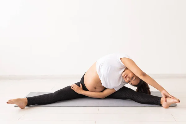 Mujer embarazada saludable haciendo gimnasia en casa. Embarazo, estilo de vida saludable y licencia por maternidad —  Fotos de Stock