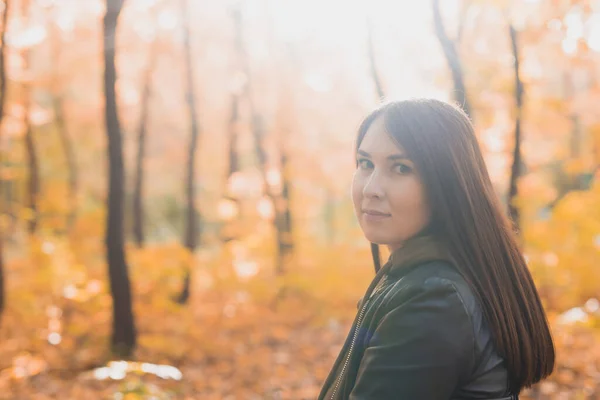 Aziatische brunette vrouw staat in een park in de herfst. Herfst en seizoen concept. — Stockfoto