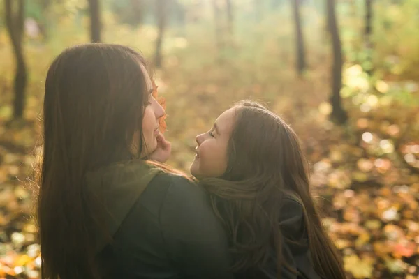 Mutter und Tochter verbringen Zeit miteinander im herbstlich gelben Park. Saison- und Alleinerziehende-Konzept. — Stockfoto